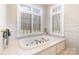 Bathroom featuring a soaking tub set under large windows, providing a relaxing spa-like atmosphere at 720 Miller Chapel Rd, Salisbury, NC 28147