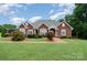 Inviting brick home with lush landscaping, a brick walkway, and a covered porch at 720 Miller Chapel Rd, Salisbury, NC 28147