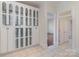 Hallway with built-in glass door cabinets offering ample storage, tiled floors, and access to additional rooms at 720 Miller Chapel Rd, Salisbury, NC 28147