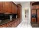 Traditional kitchen featuring dark cabinetry, granite countertops, and a tiled floor leading into the hallway at 720 Miller Chapel Rd, Salisbury, NC 28147