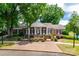 An elegant brick home with a symmetrical facade, white columns, black shutters, and manicured landscaping at 7026 Quail Hill Rd, Charlotte, NC 28210