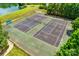 Aerial view of a community tennis court, bordering lake and trees, providing a serene setting at 7026 Quail Hill Rd, Charlotte, NC 28210