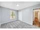 Bright bedroom with grey carpet, window, and double door closet at 1308 Rama Rd, Charlotte, NC 28211