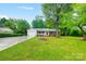 Front yard view of charming ranch home with mature trees at 1308 Rama Rd, Charlotte, NC 28211