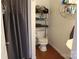 Small bathroom with toilet, sink, shelves, and shower with gray curtain at 436 E Oakwood Ave, Albemarle, NC 28001