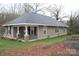 Angled view of a single-story home featuring neutral siding and a cozy front porch at 436 E Oakwood Ave, Albemarle, NC 28001