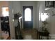 Inviting hallway with coat hooks, hardwood floors, vintage table, and an arched front door at 436 E Oakwood Ave, Albemarle, NC 28001