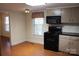 Eat-in kitchen with black appliances, light cabinets, and laminate flooring at 436 E Oakwood Ave, Albemarle, NC 28001