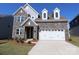 Two-story house with stone exterior, white garage door, and landscaping at 10108 Whitaker Pointe Dr, Huntersville, NC 28078