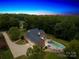 Aerial view showcases a home with a pool, lush landscaping, and surrounding greenery at 112 Berea Baptist Church Rd, Stanfield, NC 28163