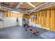 Unfinished basement ready for customization, showcasing exposed beams, concrete walls, and exercise equipment at 112 Berea Baptist Church Rd, Stanfield, NC 28163