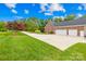 Brick home boasts an attached garage with two doors and a large driveway surrounded by green grass and mature trees at 112 Berea Baptist Church Rd, Stanfield, NC 28163