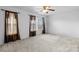 Spacious bedroom with neutral carpet, ceiling fan, and large windows at 4242 Quinn Dr, Charlotte, NC 28269