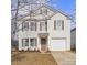 Daytime view of a two-story home with light siding, brown shutters, and a one-car garage at 4242 Quinn Dr, Charlotte, NC 28269