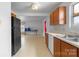 Functional kitchen with wood cabinets, white appliances, and neutral countertops overlooking bonus room at 4242 Quinn Dr, Charlotte, NC 28269