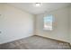 A bright bedroom with neutral carpet, a window providing natural light, and minimalist decor at 2008 Embassy Ct # 45, Charlotte, NC 28213