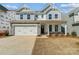 Charming two-story home with a stone facade, manicured lawn, and attached two-car garage at 2008 Embassy Ct # 45, Charlotte, NC 28213
