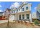Inviting two-story home featuring stone accents, a covered porch, and a well-maintained front yard at 2008 Embassy Ct # 45, Charlotte, NC 28213