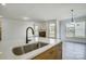 Kitchen island with stainless steel sink and faucet, overlooking the living room with fireplace at 2008 Embassy Ct # 45, Charlotte, NC 28213