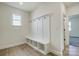 Mudroom with built-in bench, cubbies, coat hooks, and a small window, enhanced by light wood-look floors at 2008 Embassy Ct # 45, Charlotte, NC 28213