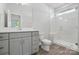 Modern bathroom featuring a glass-enclosed shower, sleek gray vanity, and wood-look flooring at 3253 Mcharney Dr # 27, Harrisburg, NC 28075