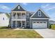 Charming two-story home with gray siding, white trim, a balcony, and a two-car garage at 3253 Mcharney Dr # 27, Harrisburg, NC 28075