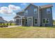 View of the back exterior featuring a patio, screened-in porch, and green lawn at 3253 Mcharney Dr # 27, Harrisburg, NC 28075