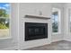 Close up view of the fireplace featuring white paneling, a dark mantle, and two bright windows at 3253 Mcharney Dr # 27, Harrisburg, NC 28075