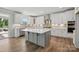 Bright, modern kitchen featuring white cabinets, a large island, and hardwood flooring at 3253 Mcharney Dr # 27, Harrisburg, NC 28075