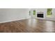 Bright living room featuring hardwood floors, three windows, and a black fireplace at 3253 Mcharney Dr # 27, Harrisburg, NC 28075