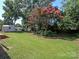 A spacious, grassy backyard features a small shed, a fence, and flowering trees in a well-kept, serene setting at 611 Greenbriar Ave, Rock Hill, SC 29730