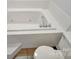 A white soaking tub with tile surround with a white toilet in the corner at 106 Cameron Dr, Kings Mountain, NC 28086