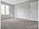 Bedroom with neutral colored carpet and walls with one window and a door at 106 Cameron Dr, Kings Mountain, NC 28086