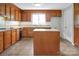 Traditional kitchen features wood cabinetry, center island, tile floors and window over the sink at 106 Cameron Dr, Kings Mountain, NC 28086
