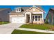 Two-story house with a beige exterior and a two-car garage at 1014 Lowland Way, Waxhaw, NC 28173