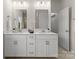 Bathroom featuring double vanity sinks, modern lighting, and linen storage at 6034 Jepson Ct, Charlotte, NC 28214