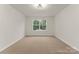 Bright, carpeted bedroom with neutral walls and natural light from a large window at 6034 Jepson Ct, Charlotte, NC 28214