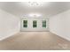 Bonus room with abundant natural light features large windows and neutral carpeting at 6034 Jepson Ct, Charlotte, NC 28214