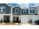 Charming townhome featuring a two-car garage and modern gray and beige siding at 1650 Village Grove Ln, Monroe, NC 28110