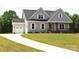 Charming gray home with a neatly manicured lawn and a concrete driveway leading to an attached garage at 1228 Sage Pine Cir # 12, Clover, SC 29710