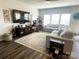 Bright living room featuring an L-shaped sofa, large windows, dark wood-style flooring, and a ceiling fan at 3524 Tully Ave, Kannapolis, NC 28081