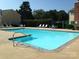 Community swimming pool with lounge chairs and umbrellas at 3178 Heathstead Pl, Charlotte, NC 28210