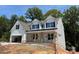 Two story home with white siding, gray stone accents, and a three-car garage at 3245 Mcharney Dr # 28, Harrisburg, NC 28075