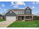 Two-story home with gray siding, white trim, and a two-car garage at 117 Brooke Forest Ct, Mooresville, NC 28115