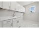 Laundry room with white cabinets, quartz countertops, and a utility sink at 117 Brooke Forest Ct, Mooresville, NC 28115