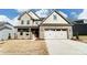 Brick two-story house with a three-car garage and landscaped lawn at 3221 Mcharney Dr # 31, Harrisburg, NC 28075