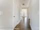 Long hallway with hardwood floors and white walls at 3221 Mcharney Dr # 31, Harrisburg, NC 28075