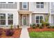Townhome entrance with green door, stone accents, and landscaping at 10511 Boudreaux St, Huntersville, NC 28078