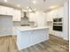 Modern kitchen with white cabinets, large island, and stainless steel appliances at 10511 Boudreaux St, Huntersville, NC 28078