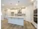 Modern kitchen with white cabinets, large island, and stainless steel appliances at 10511 Boudreaux St, Huntersville, NC 28078